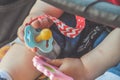 A close up of a baby hand holding a pacifier and a toy Royalty Free Stock Photo