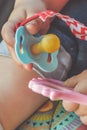 A close up of a baby hand holding a pacifier and a toy Royalty Free Stock Photo