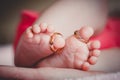 Close up of baby`s feet with wedding rings in mother`s hands. Newborn. Selective focus Royalty Free Stock Photo