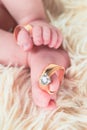 Close up of baby's feet with wedding rings. Newborn. Selective focus Royalty Free Stock Photo