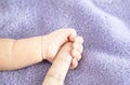 Close up, Baby`s hand holding a parent`s finger, symbolic of love, protection for a newborn. Royalty Free Stock Photo