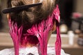 Close-up of the back of the head of the dyed strands of blond hair in a bright pink color, beauty salon