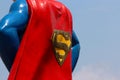 Close up of the back of a metal statue of Superman. The statue has a red cape with a yellow Royalty Free Stock Photo