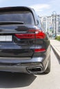 Close-up of the back of a new black prestige car, an expensive status car SUV, headlights, radiator grille, bumper, hood