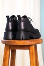 Close-up back side of black elegant shoes on wooden background. Leather winter boots, stylish lady footwear concept Royalty Free Stock Photo