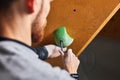 Close up back view of boulderer with physical disability screwing holds at rock wall