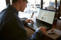 Close-up back view of caucasian businessman hands typing on laptop keyboard and using touchpad. Notebook and pen on Royalty Free Stock Photo