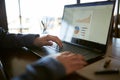 Close-up back view of caucasian businessman hands typing on laptop keyboard and using touchpad. Notebook and pen on Royalty Free Stock Photo