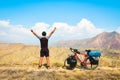 Close up back view inspirational excited joyful caucasian male cyclist on viewpoint by red touring bicycle in deserted mountains Royalty Free Stock Photo