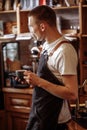 A cheerful waiter with a cup of coffee and a mobile phone