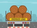 Close-up back view of a trailer loaded with huge tree trunks. Oversize load warning sign.