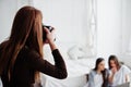 Close up back of young girl photographer shooting on studio two girls who are watching laptop. Professional photographer on work Royalty Free Stock Photo