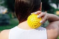 close-up on back of young woman doing neck and shoulder massage with spiky rubber ball, relaxing tense neck muscles Royalty Free Stock Photo