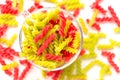 Close-up background of Fusille and Rotini in a glass bowl on white. pasta