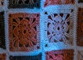 Close-up background image of a variegated knitted blanket with a colorful graphic design