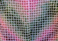 Close-up background image of a variegated knitted blanket with a colorful graphic design