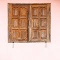 Old wooden windows with pink concrete walls