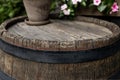 Close-up background of top of old retro vintage weathered wooden cask barrel with flower pot. Wineyard, distillery, pub Royalty Free Stock Photo