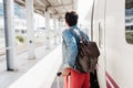 Close up of backpacker caucasian woman holding luggage at train station ready to catch the train. Holding mobile phone while using Royalty Free Stock Photo