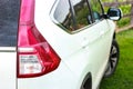 Close up backside of dirty car. rear view of white car on green grass background in country house Royalty Free Stock Photo