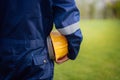 Close-up backside view of engineering male construction worker holding safety yellow helmet