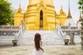 Close up backside young Asian woman in a white shirt taking a photo by camera beautiful temple during the summer season while