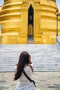 Close up backside young Asian woman in a white shirt taking a photo by camera beautiful temple during the summer season while