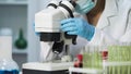 Close-up of bacteriologist viewing samples of bacteria on microscope, virology