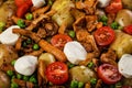 Close-up baked potatoes, carrots, green peas, chanterelles with mozzarella cheese. Edible forest mushrooms and organic vegetables