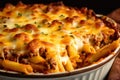 Close-up of a baked ziti pie, with crispy edges and layers of pasta, cheese, and meat, in a deep-dish baking pan