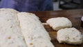 Close up for baker cutting dough into pieces before cooking and weighing them at the bakery. Stock footage. Woman making Royalty Free Stock Photo