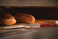 Close-up of a baker's shovel taking freshly baked artisan bread out of the oven. Bread production with copy space Royalty Free Stock Photo