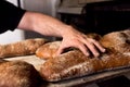 Close up of baker touching and testing fresh hadmade bread with flour in bakery shop. concept of passion and care for a handmade Royalty Free Stock Photo