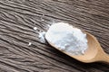 Close up of baking soda (sodium bicarbonate) in a wooden spoon on the table. Royalty Free Stock Photo