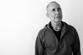Close up of bald senior man thinking while looking up against white background Royalty Free Stock Photo
