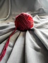 Wool red ball with grey fabric underneath