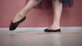 Close-up of ballerina`s legs in black pointe shoes. Action. Ballerina in black czechs and mesh tights kneads her legs Royalty Free Stock Photo