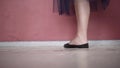 Close-up of ballerina`s legs in black pointe shoes. Action. Ballerina in black czechs and mesh tights kneads her legs