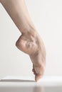 Close-up ballerina`s legs on the white floor