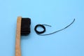 Close-up of bamboo black toothbrush and black dental floss on blue background. Copyspace.