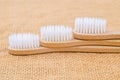 Close up Bamboo toothbrush with green leaf on sack background