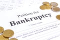 Close-up bancruptcy petition and golden coins. Application form Royalty Free Stock Photo
