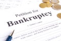 Close-up bancruptcy petition, pen and golden coins Royalty Free Stock Photo