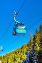 Close up Bansko cable car cabin, pine trees against vibrant blue sky, Bulgaria