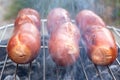 Close up barbecue grill with meat and sausages cooking during summer garden party Royalty Free Stock Photo