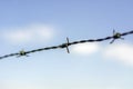 Close up barbed wire against blue sky