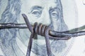 Close up barbed wire against US Dollar bill as symbol of bribery in politics, business, diplomacy. Horizontal image