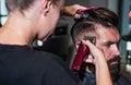 Close-up of barber styling beard to male in barbershop, Personal stylist barber
