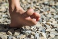 Close-up of bare foot walking on stones, outdoors activity