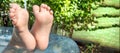 Close-up -bare wet feet of a baby boy playing in an inflatable pool in summer, lifting his legs, cute funny photo Royalty Free Stock Photo